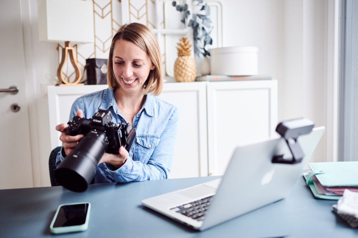 Food Fotografin mit Kamrea vor dem Laptop sitzend