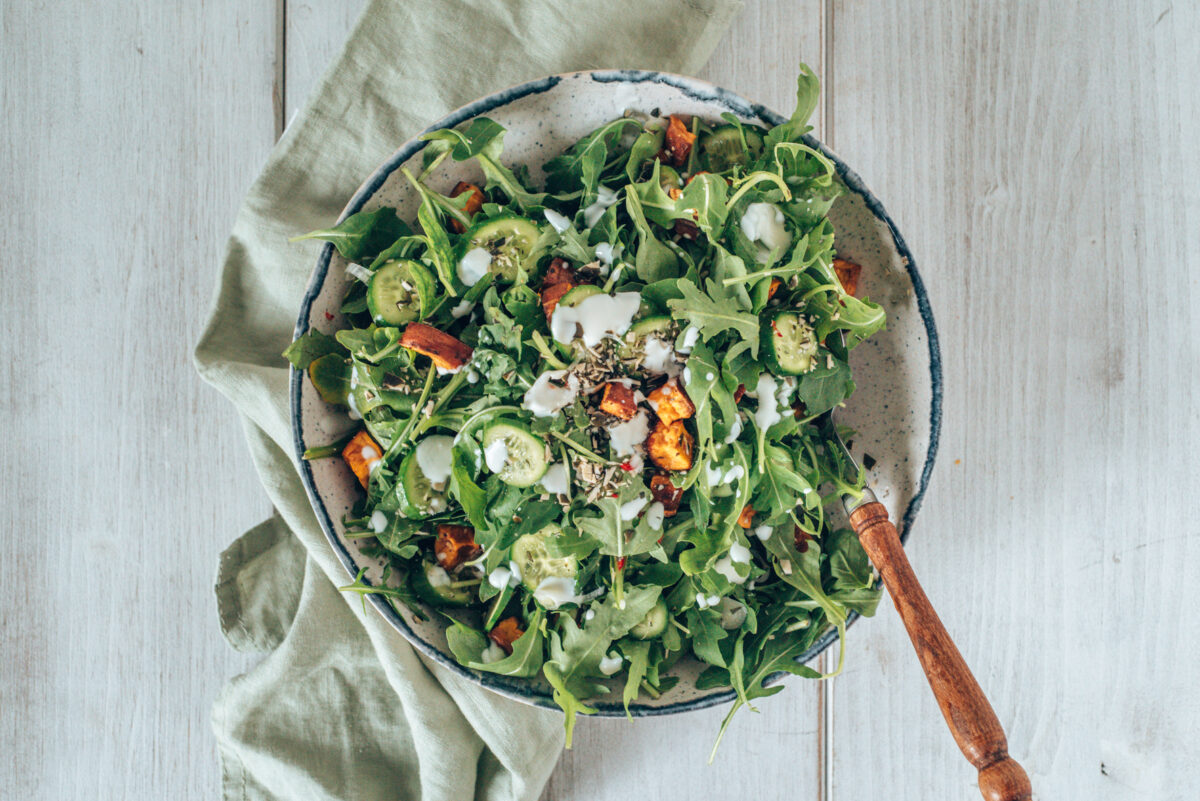 Süßkartoffelsalat mit Rucola auf einer grünen Stoffserviette