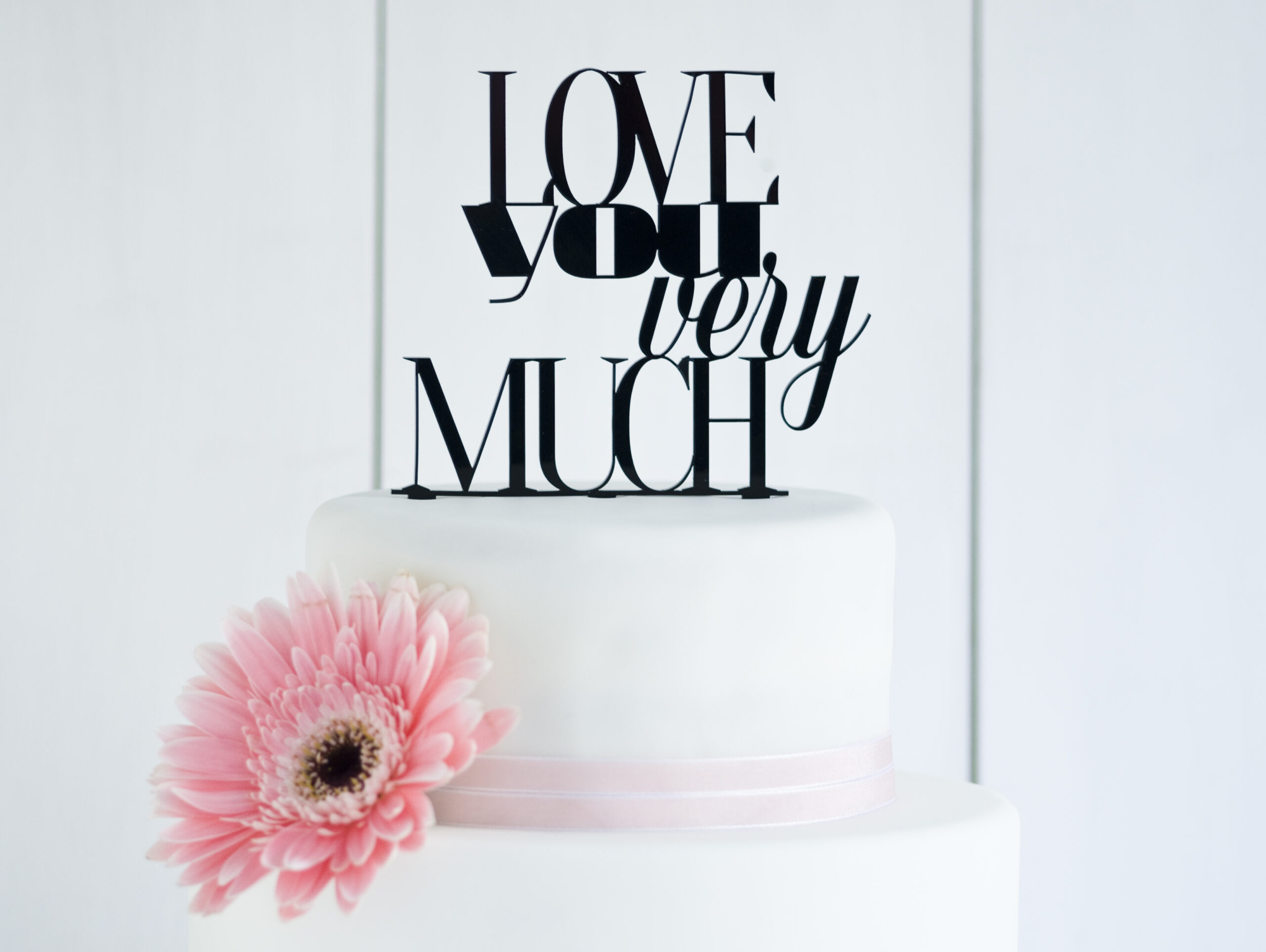 Weiße Fondanttorte mit pinker Gerbera und Cake Popper